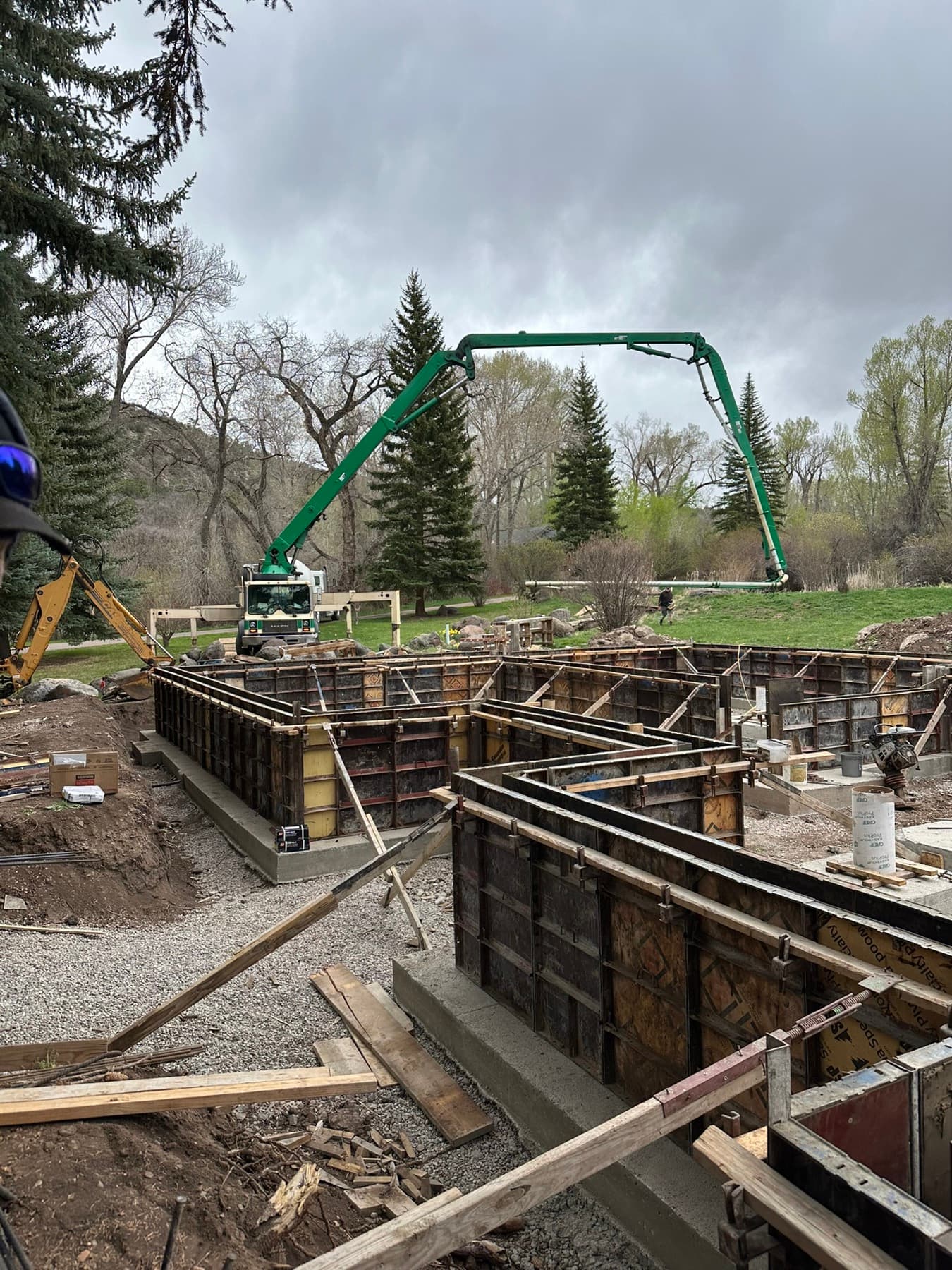 Concrete pump truck pouring a foundation wall with formwork set, structural concrete pour