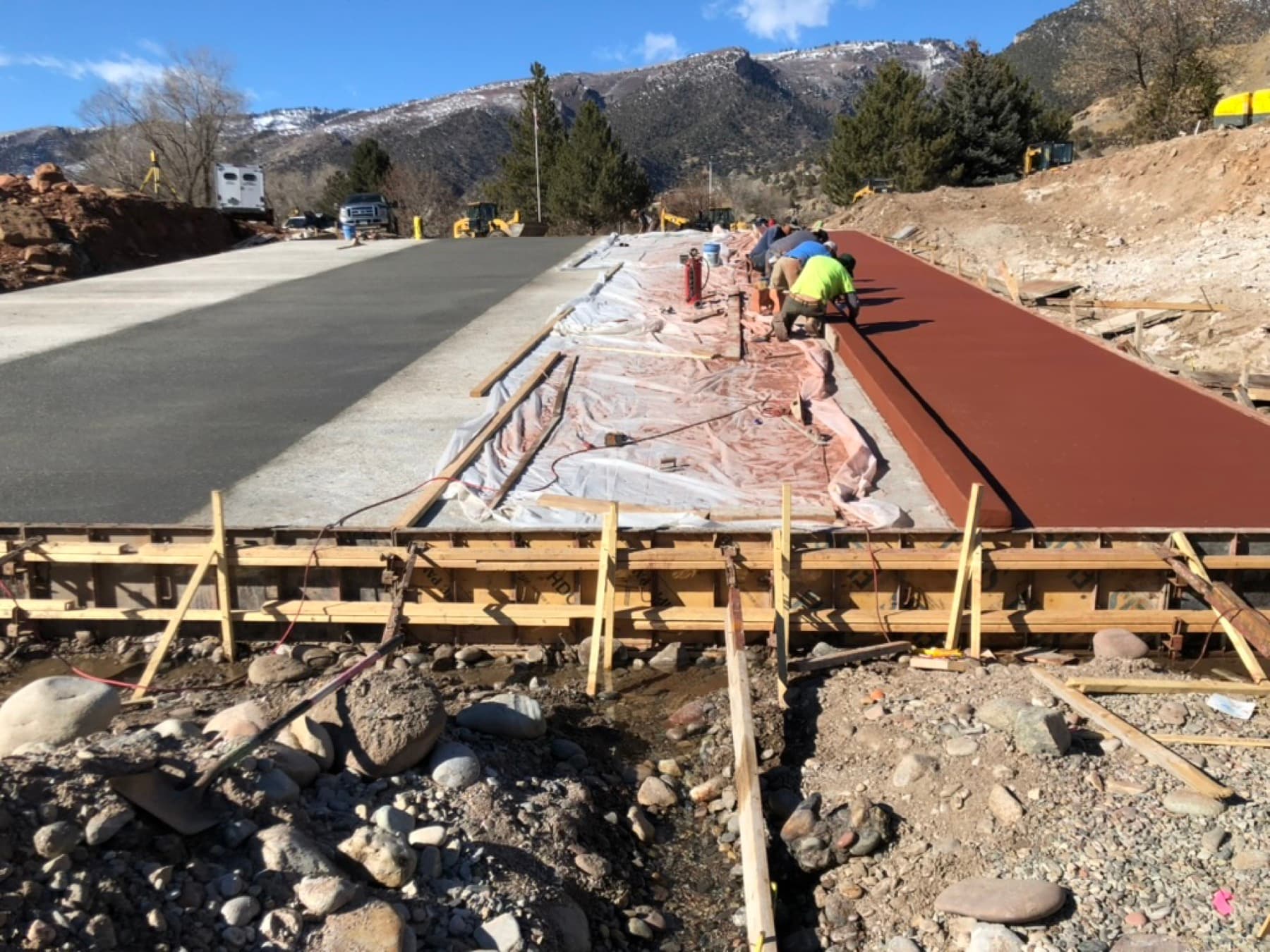 Colored concrete driveway pour alongside a standard slab