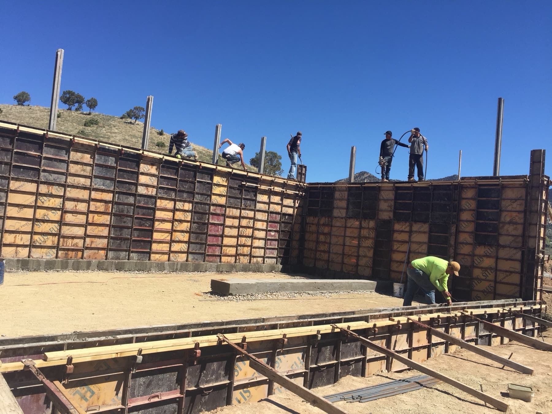 Crew working foundation formwork on a hillside site