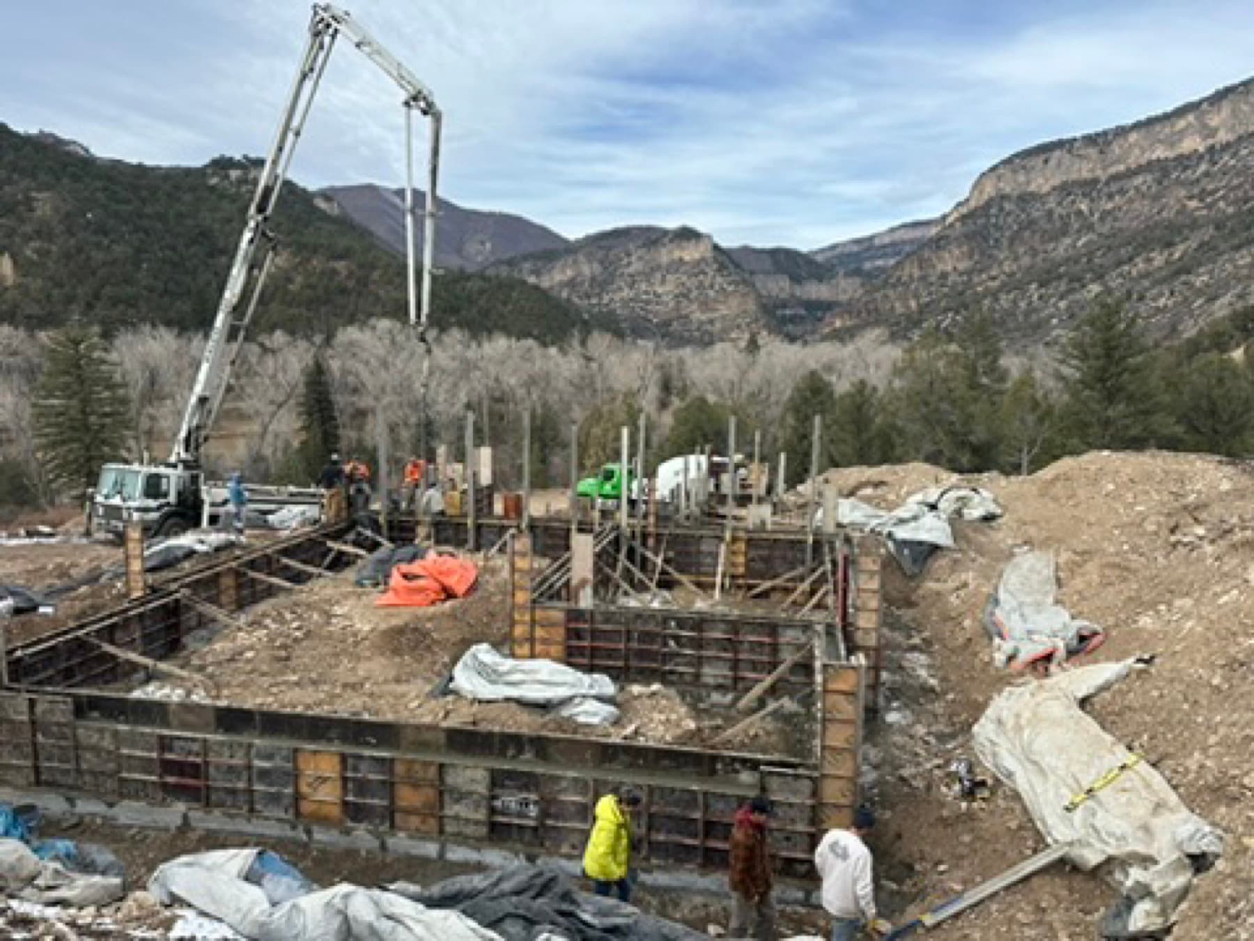 Concrete pump truck pouring a foundation, mountain valley