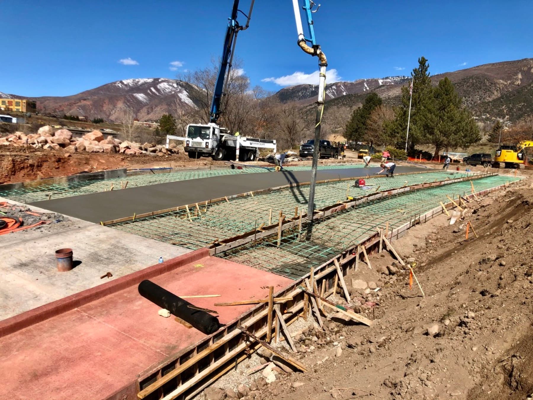Slab pour with rebar mesh, snow-capped mountains behind