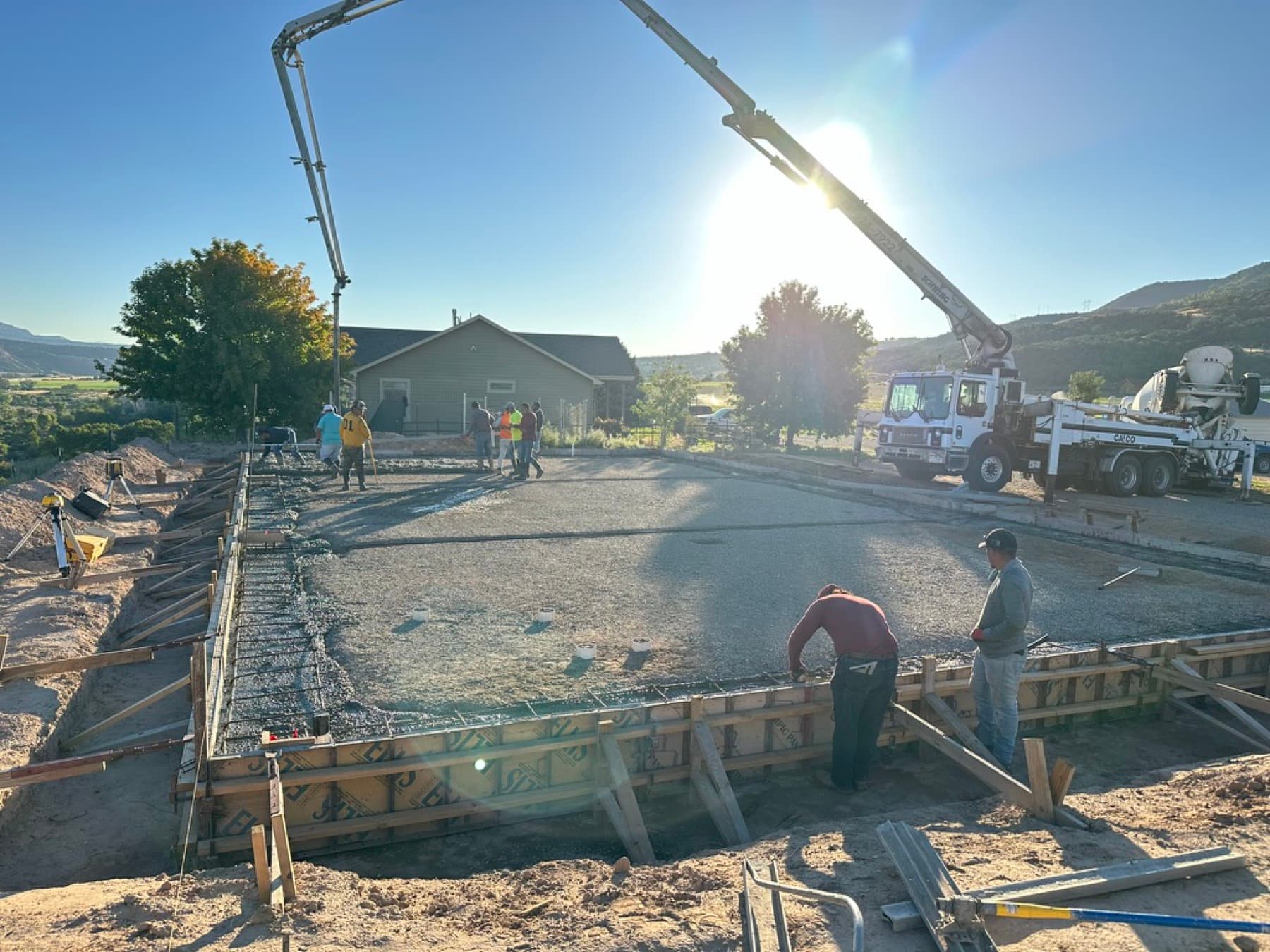 Slab pour at sunrise beside a finished home